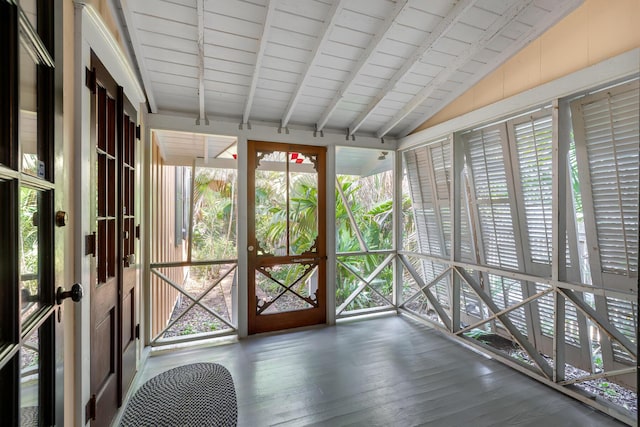 unfurnished sunroom with vaulted ceiling with beams