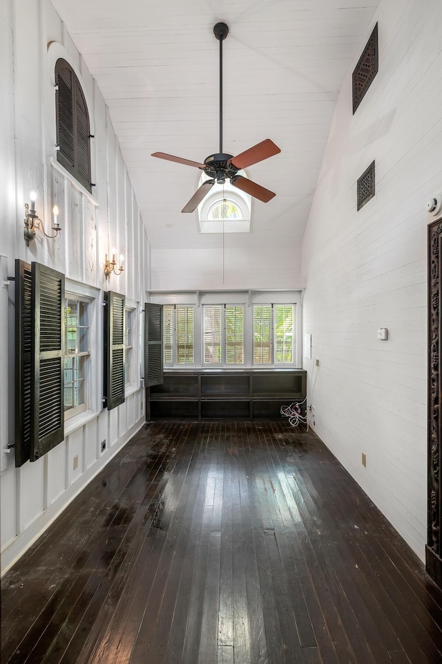 unfurnished living room with dark wood-type flooring, high vaulted ceiling, and ceiling fan