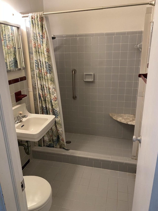 bathroom featuring toilet, curtained shower, and sink