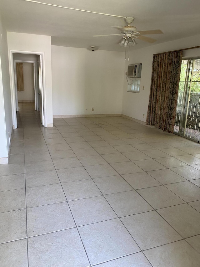 tiled empty room featuring a wall mounted air conditioner and ceiling fan