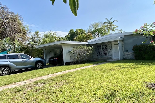 ranch-style house featuring a carport and a front yard