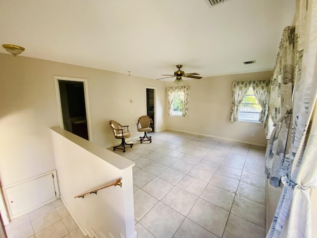 tiled empty room featuring ceiling fan