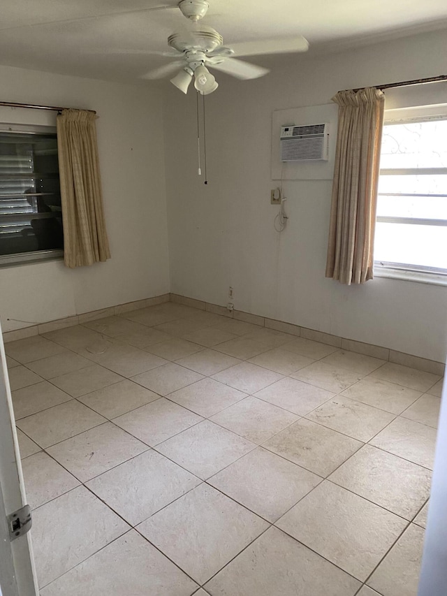 tiled spare room featuring a wall unit AC and ceiling fan