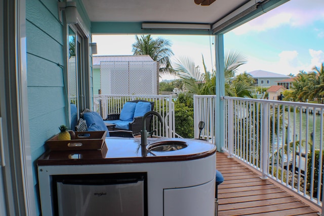 balcony featuring a water view and ceiling fan