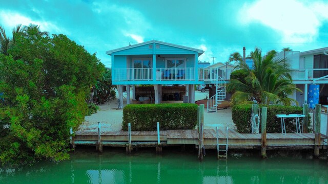 back of property featuring a patio area, a balcony, and a water view