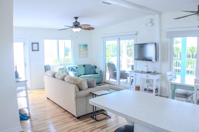 living room with lofted ceiling, light wood-type flooring, and ceiling fan