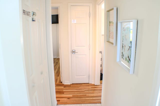 hallway with hardwood / wood-style flooring