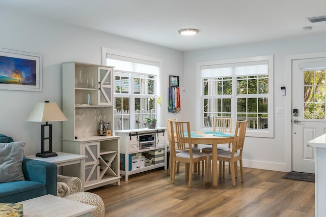 dining space with wood finished floors and baseboards