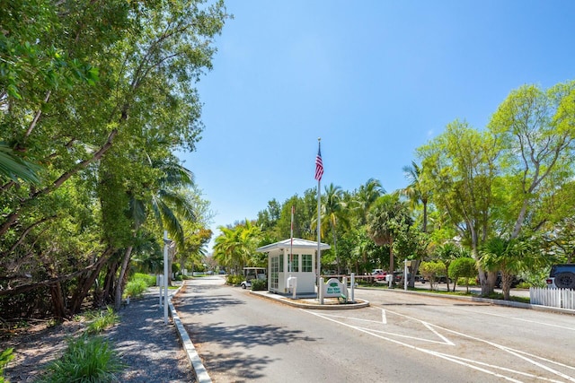 view of street featuring a gated entry and curbs