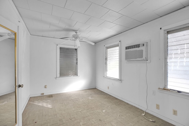 unfurnished room with baseboards, ceiling fan, and a wall unit AC