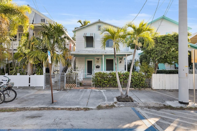 view of front of home featuring a porch, fence, and a gate