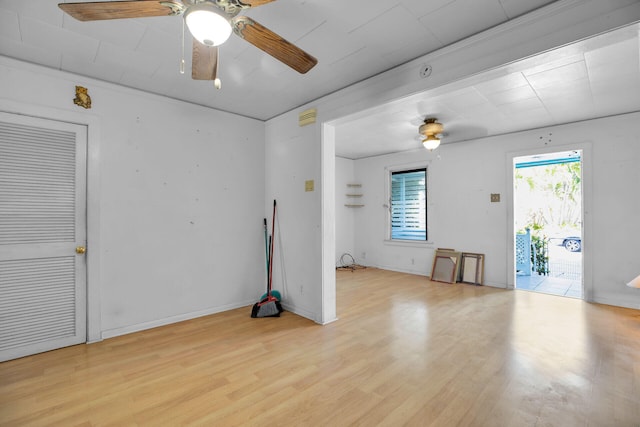 empty room featuring baseboards, light wood-type flooring, and a ceiling fan