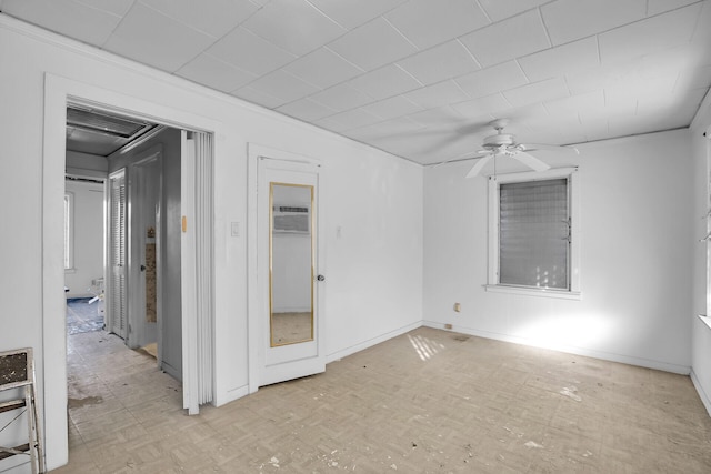 unfurnished room featuring baseboards, a wall mounted AC, and ceiling fan