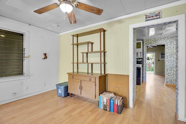 unfurnished room with a ceiling fan, crown molding, and wood finished floors