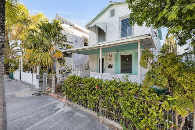 view of front of house with a fenced front yard, a porch, and a gate