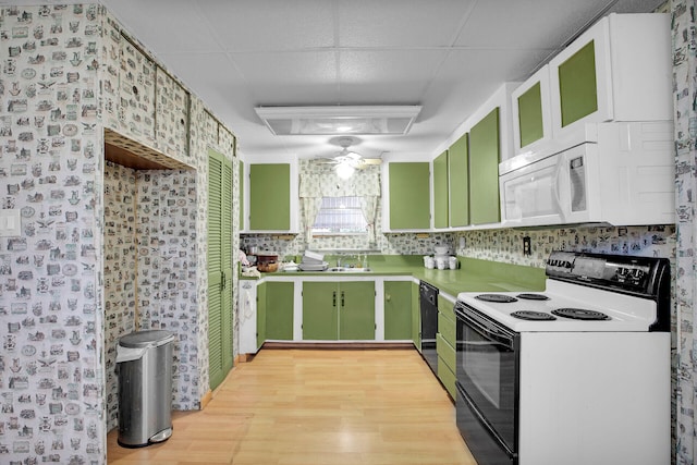 kitchen featuring green cabinets, light wood-style flooring, white microwave, and range with electric cooktop