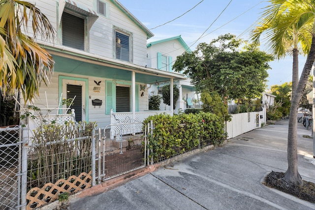 view of front of house featuring a porch, a gate, and a fenced front yard