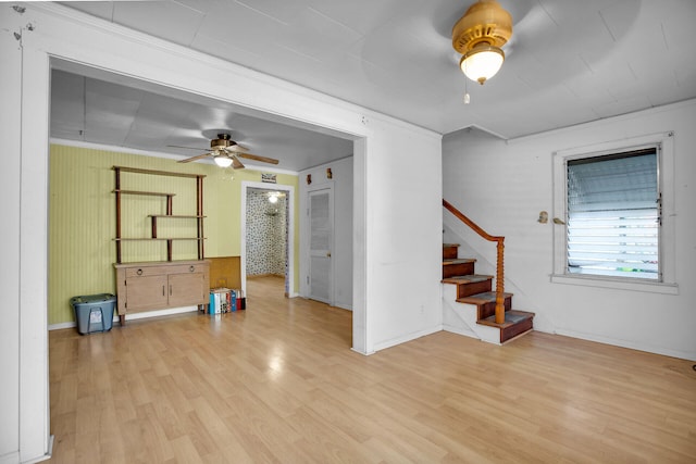 interior space featuring baseboards, stairs, ceiling fan, and wood finished floors