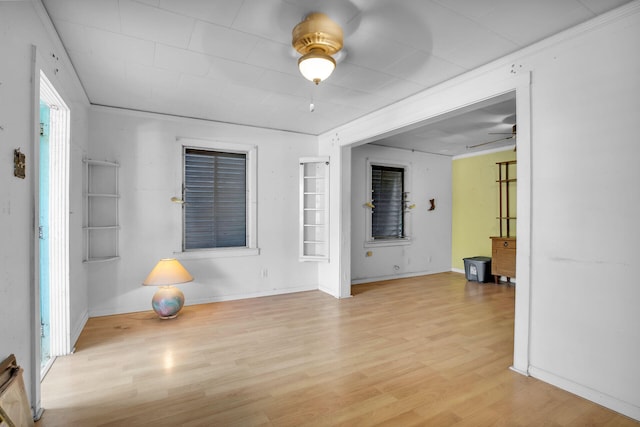 unfurnished room with baseboards, light wood-style floors, and a ceiling fan