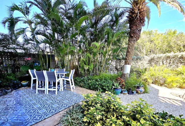 view of patio featuring outdoor dining area and fence