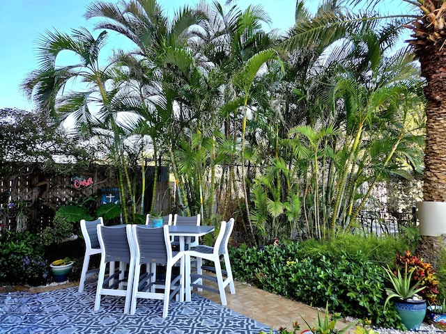 view of patio featuring outdoor dining area and fence