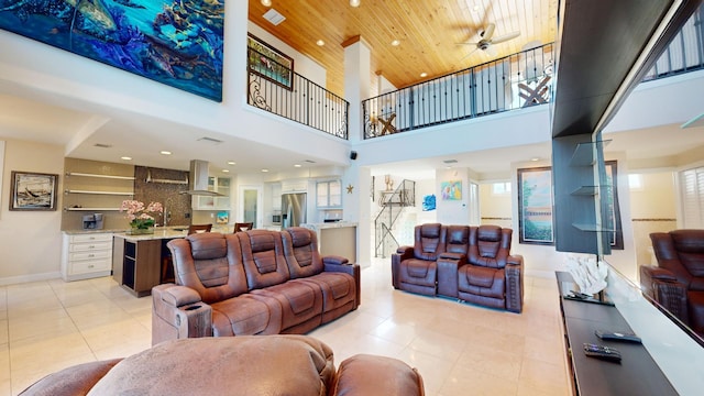 living room with light tile patterned floors, wood ceiling, and a towering ceiling