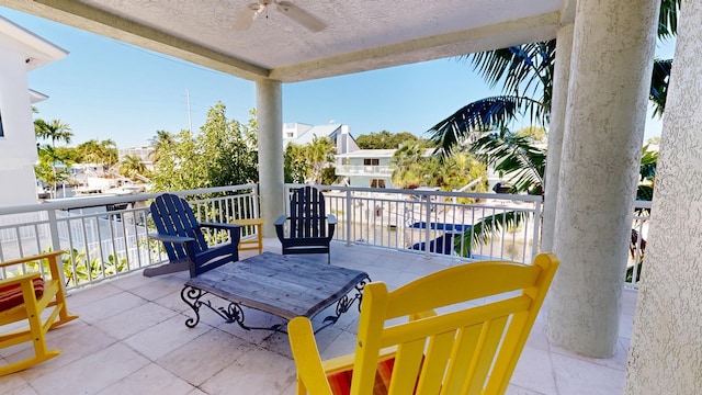 view of patio with ceiling fan and a balcony