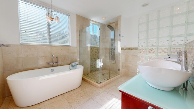 bathroom with tile walls, sink, tile patterned flooring, and plus walk in shower