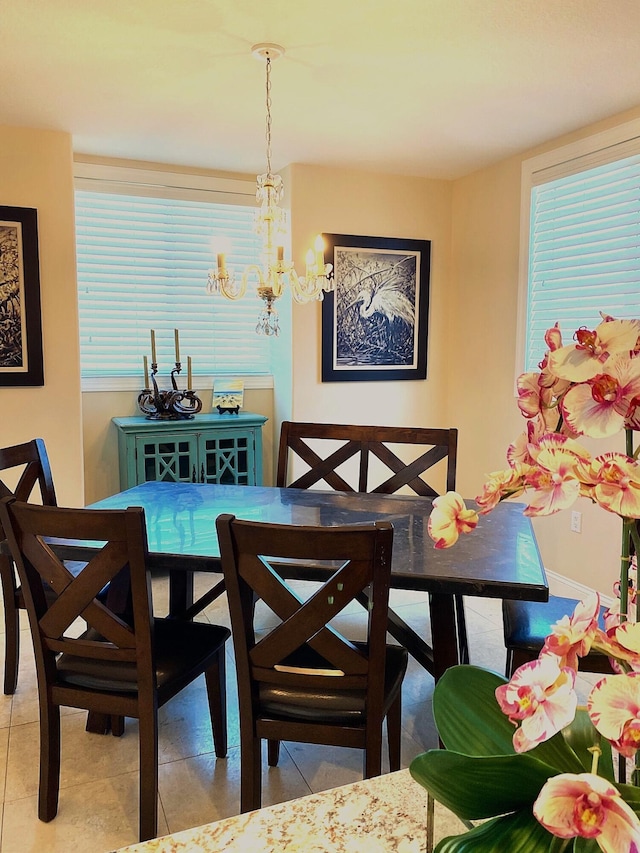 tiled dining space featuring a notable chandelier