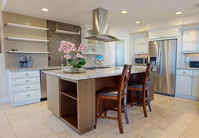 kitchen with a kitchen island, appliances with stainless steel finishes, island range hood, and white cabinets