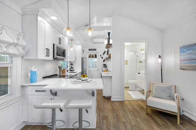 321 Julia St, Key West, FL 33040 - kitchen with stainless steel appliances, white cabinetry, vaulted ceiling, dark wood-style floors, and light countertops