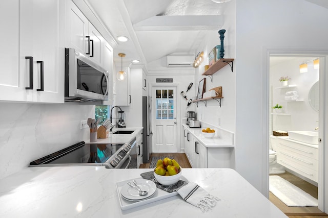 321 Julia St, Key West, FL 33040 - kitchen with stainless steel appliances, open shelves, white cabinetry, a wall mounted air conditioner, and light stone countertops