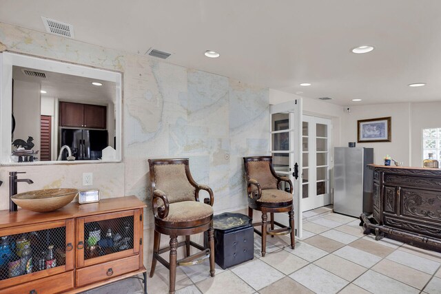 sitting room with french doors, light tile patterned flooring, and sink