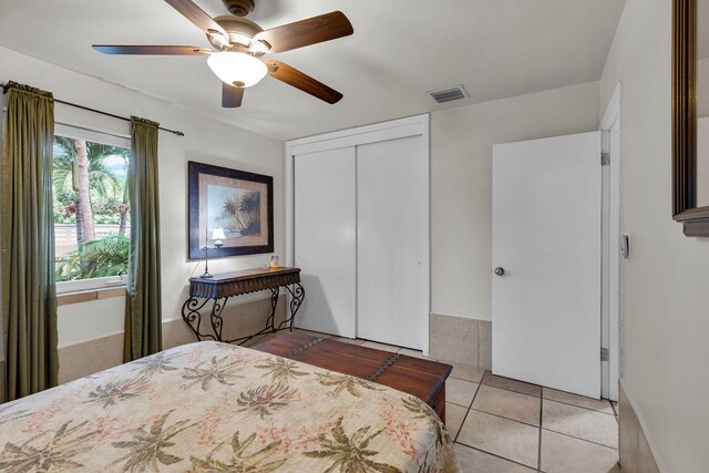 bedroom featuring light tile patterned flooring, ceiling fan, and a closet