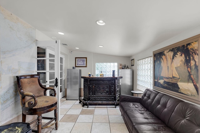 tiled living room featuring vaulted ceiling