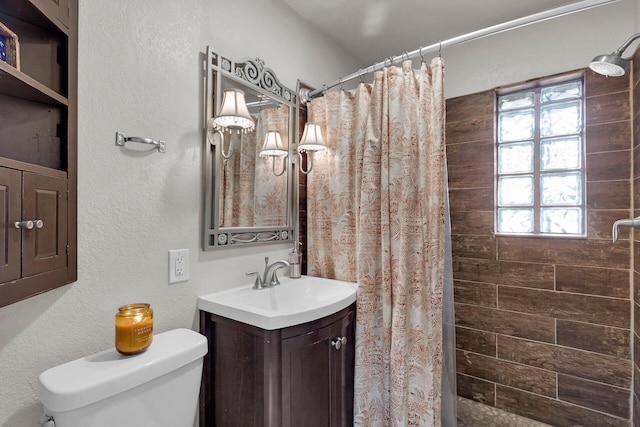 bathroom featuring vanity, toilet, and walk in shower