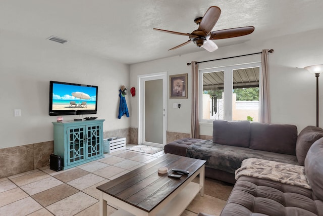 tiled living room featuring a textured ceiling and ceiling fan