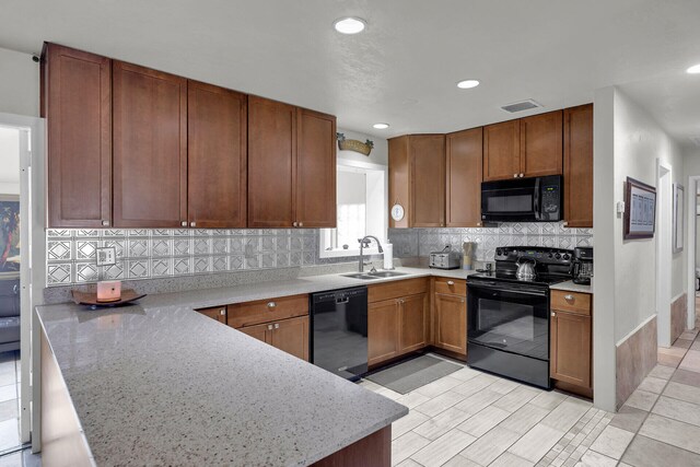 kitchen with black appliances, sink, decorative backsplash, kitchen peninsula, and light stone countertops