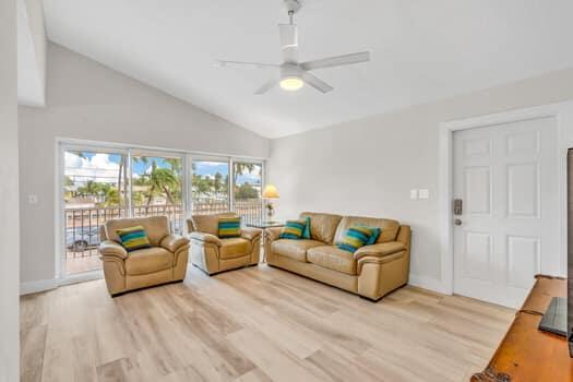 living room featuring ceiling fan, high vaulted ceiling, and light hardwood / wood-style flooring