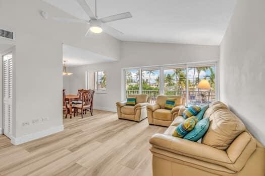 living room featuring light hardwood / wood-style flooring, high vaulted ceiling, and ceiling fan