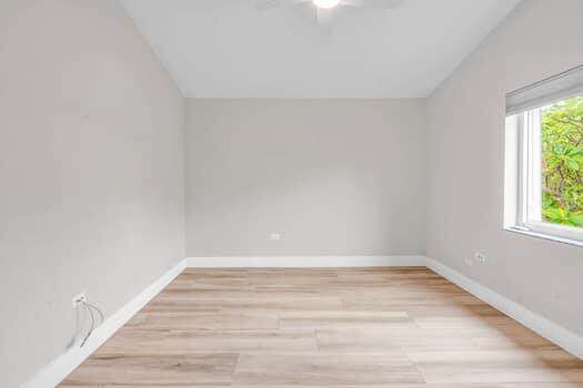 spare room with lofted ceiling and light hardwood / wood-style flooring