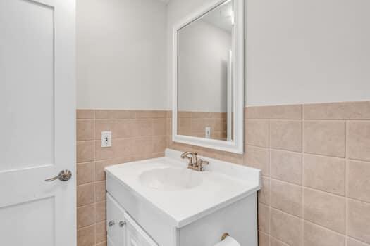 bathroom with vanity and tile walls