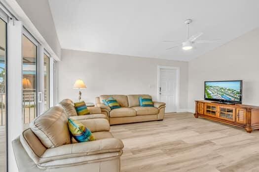 living room with ceiling fan, lofted ceiling, and light hardwood / wood-style floors