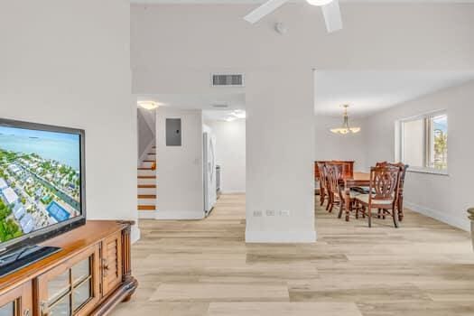 interior space featuring a high ceiling, ceiling fan, and light wood-type flooring