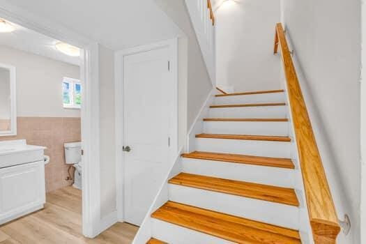 stairs featuring wood-type flooring and tile walls