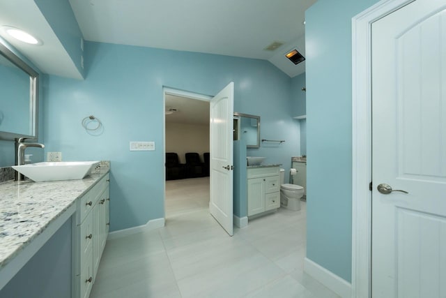 bathroom with vanity, vaulted ceiling, and toilet