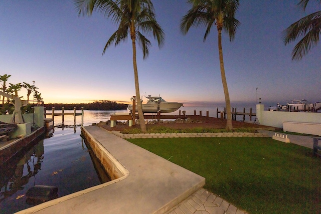 dock area with a yard and a water view