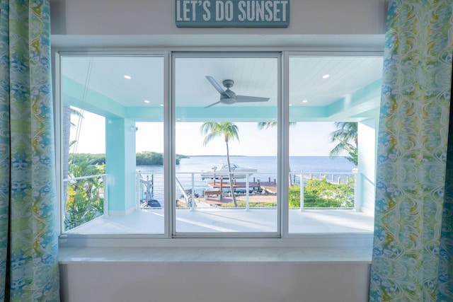 doorway to outside featuring a water view and ceiling fan