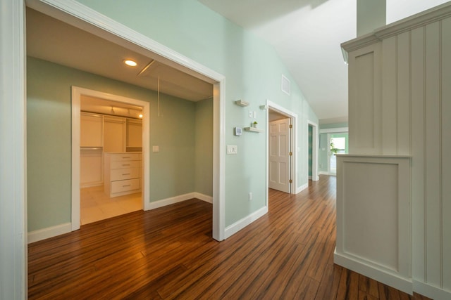 hall featuring dark wood-type flooring and vaulted ceiling