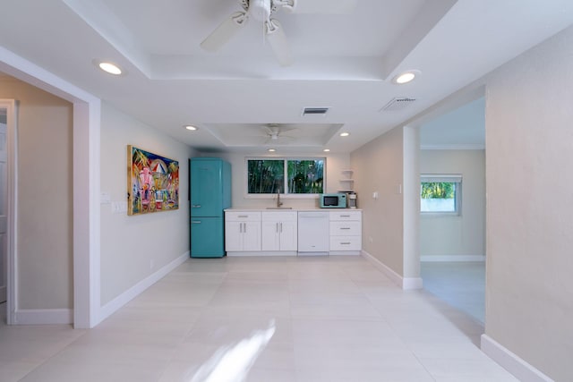 interior space with a raised ceiling, vanity, tile patterned floors, and ceiling fan